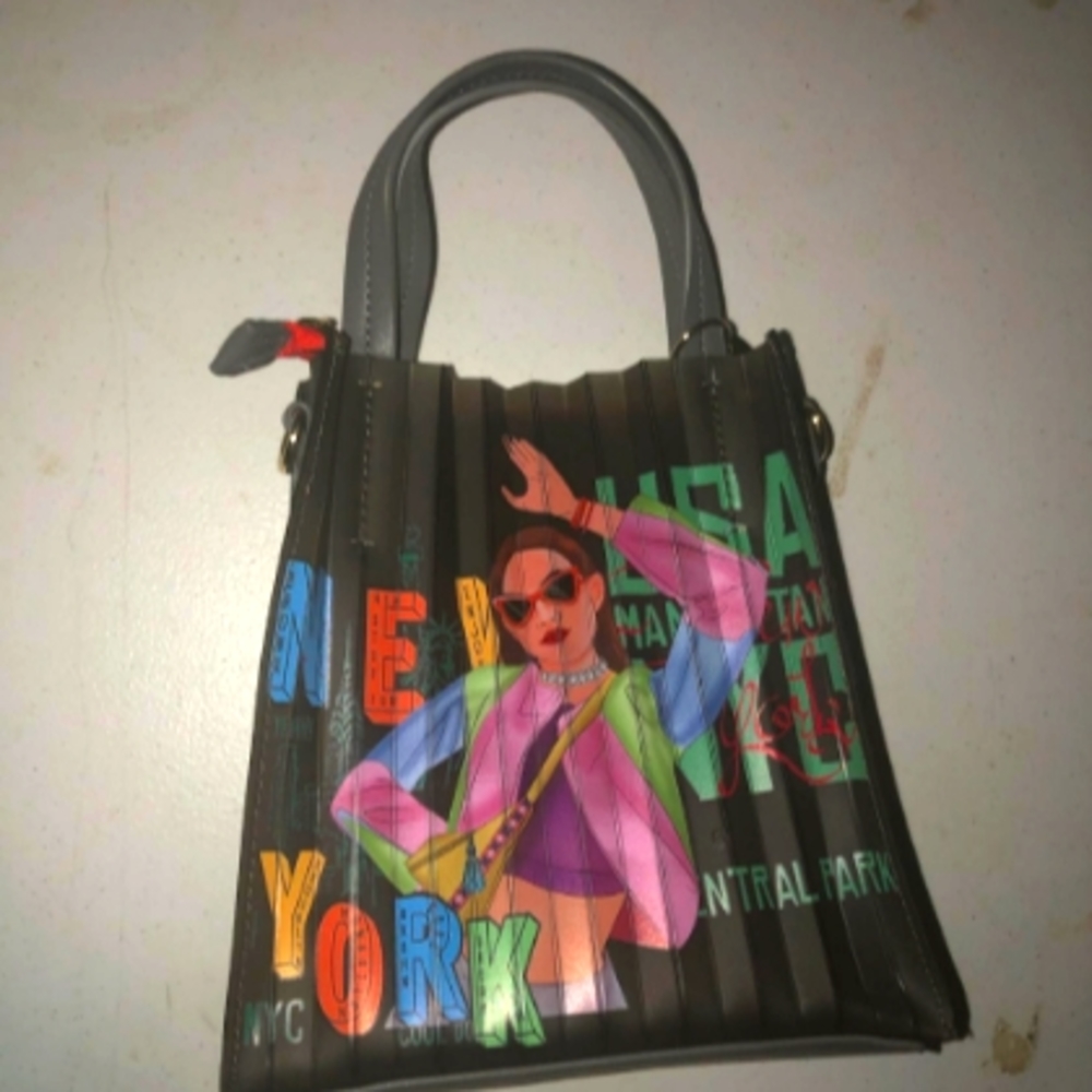 Its a grey,yellow, orange,green medium small hand bag the brand is nikky.